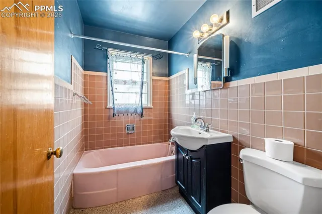 a bathroom with a sink and mirror with bathtub