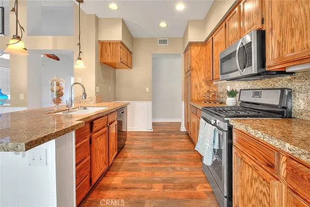 a kitchen with stainless steel appliances granite countertop a sink and a stove