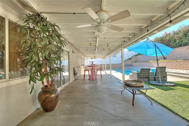 a view of a patio with table and chairs under an umbrella