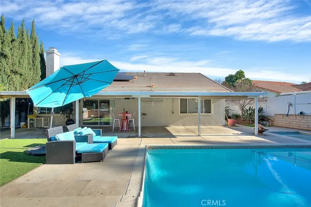 a patio with a table and chairs under an umbrella