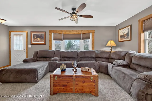 a living room with furniture ceiling fan and a window