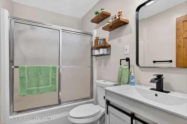 a bathroom with a sink vanity mirror and toilet