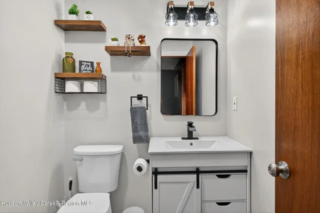 a bathroom with a toilet sink and mirror
