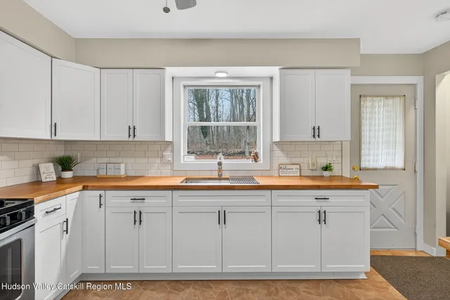 a kitchen with white cabinets and sink