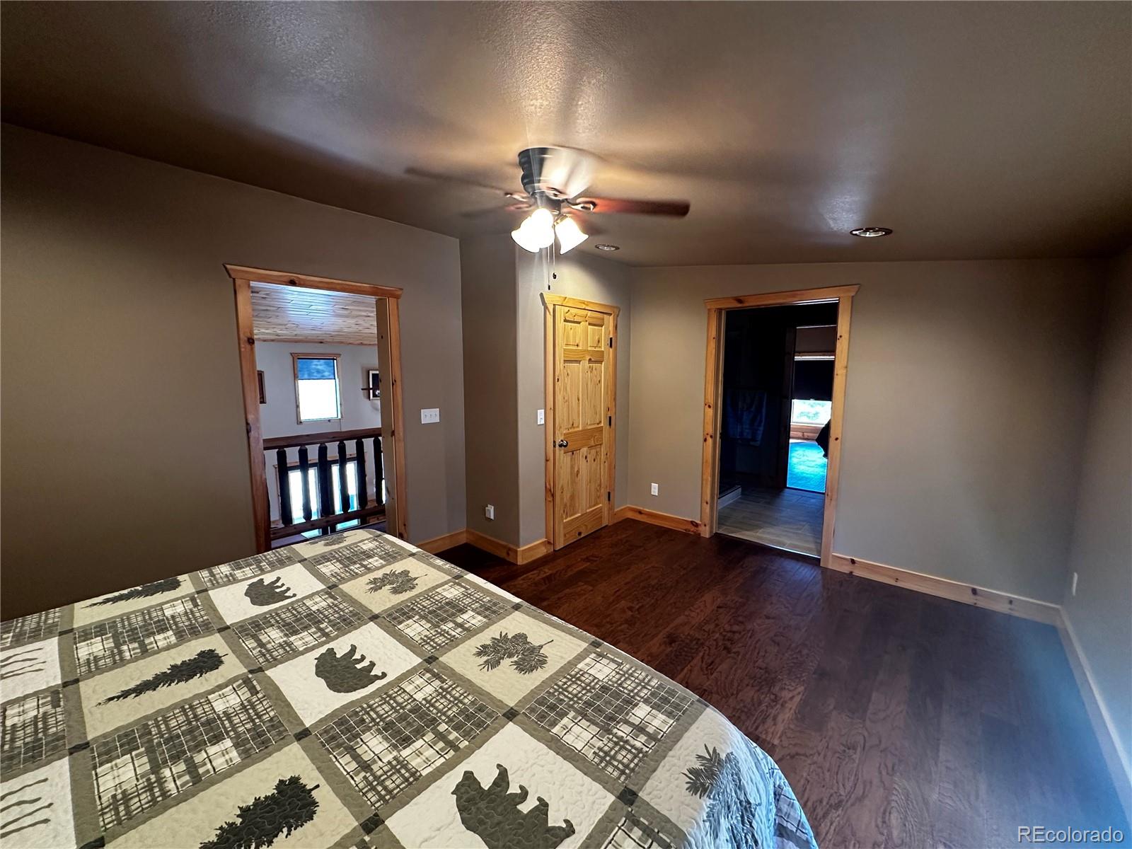 3744 Icehouse Road Fort Garland, CO 81133 - Photo 22 of 48 a bedroom with a large bed and a chandelier