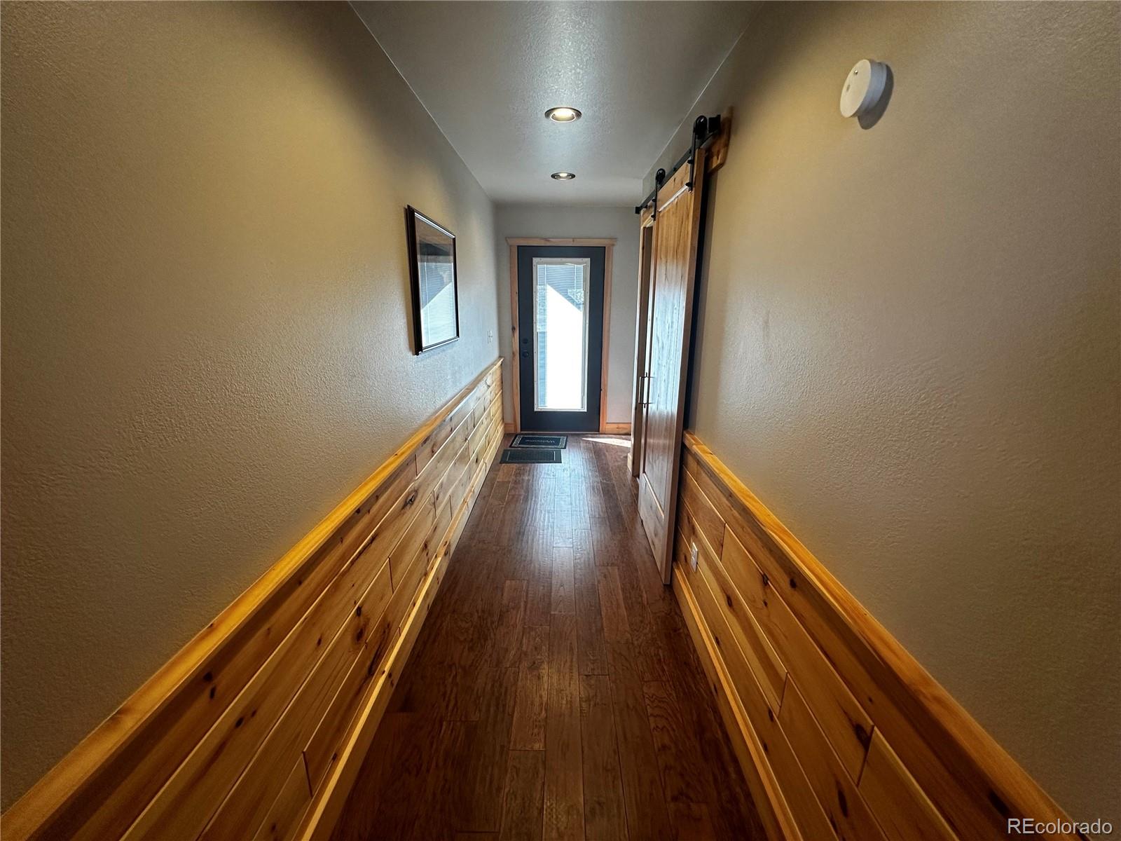 3744 Icehouse Road Fort Garland, CO 81133 - Photo 35 of 48 a view of a hallway with wooden floor and stairs
