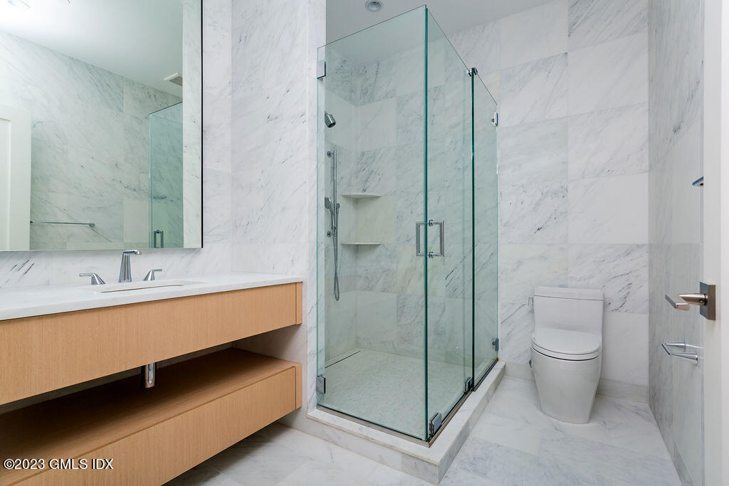 89 River Road, Unit 203 Cos Cob, CT 06807 - Photo 15 of 26 a bathroom with a double vanity sink toilet and shower
