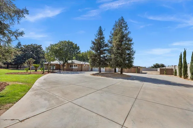 a front view of a house with a yard and trees