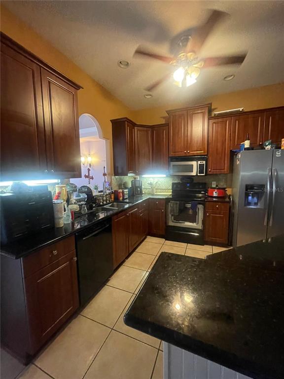 396 Kettering Road Deltona, FL 32725 - Photo 11 of 25 a kitchen with granite countertop a stove and cabinets