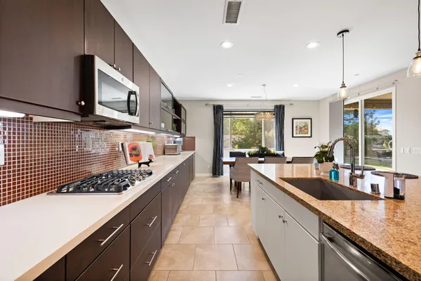 a dining area with stainless steel appliances kitchen island granite countertop a dining table and chairs