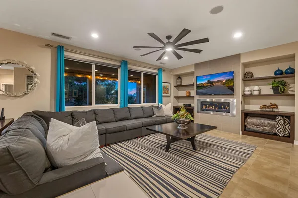 a living room with furniture flat screen tv and a large window