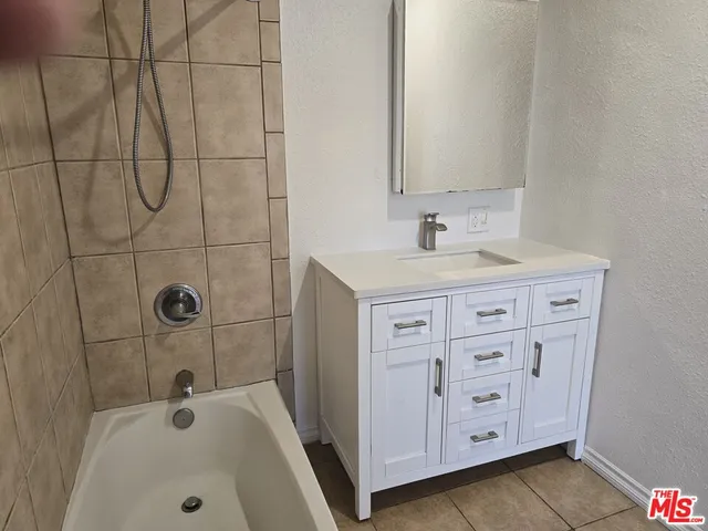 a bathroom with a sink a vanity and tub