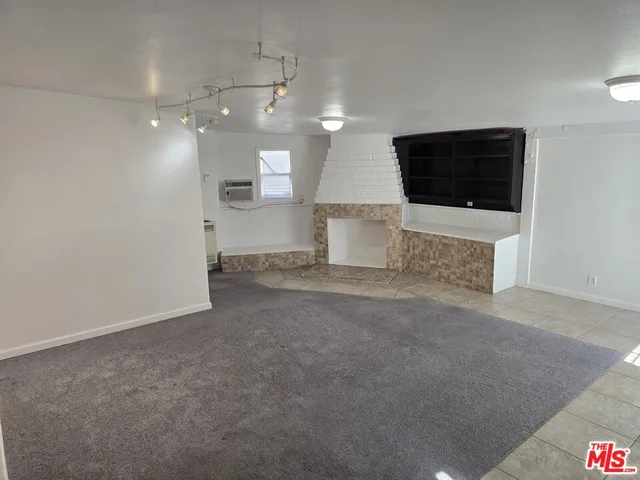 a view of a livingroom with a kitchen space and a window