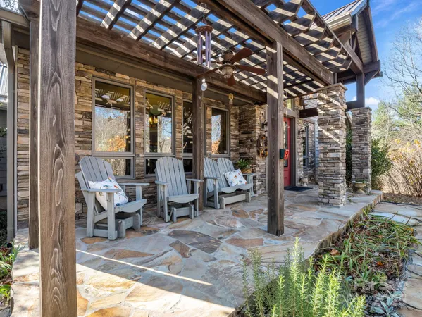 a view of a porch with chairs and potted plants