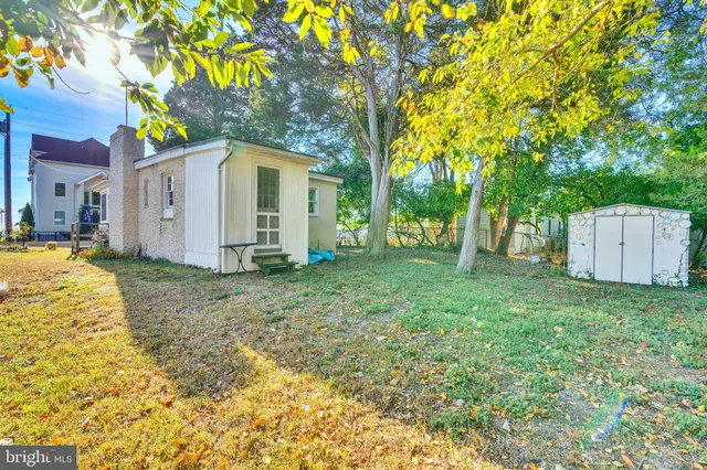 a view of a house with backyard and tree