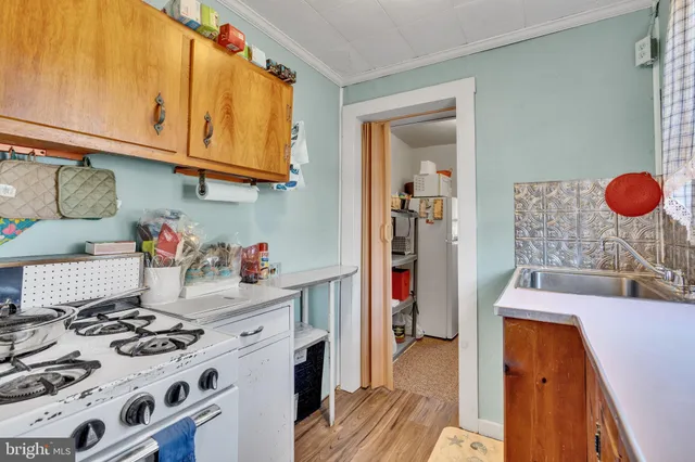 a kitchen with stainless steel appliances granite countertop a stove and a wooden floor
