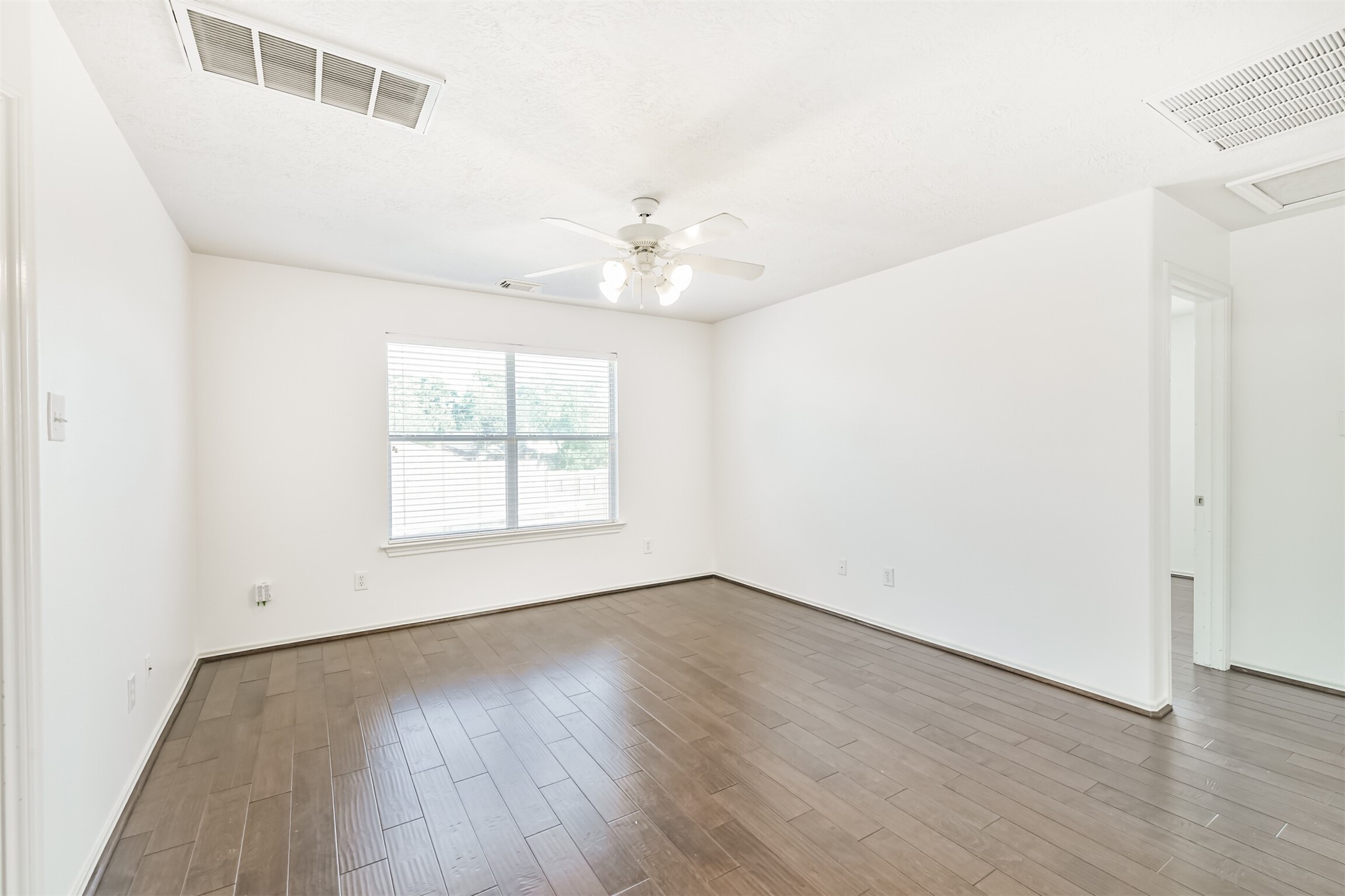 2507 Liza Court Spring, TX 77388 - Photo 23 of 37 an empty room with wooden floor chandelier fan and windows
