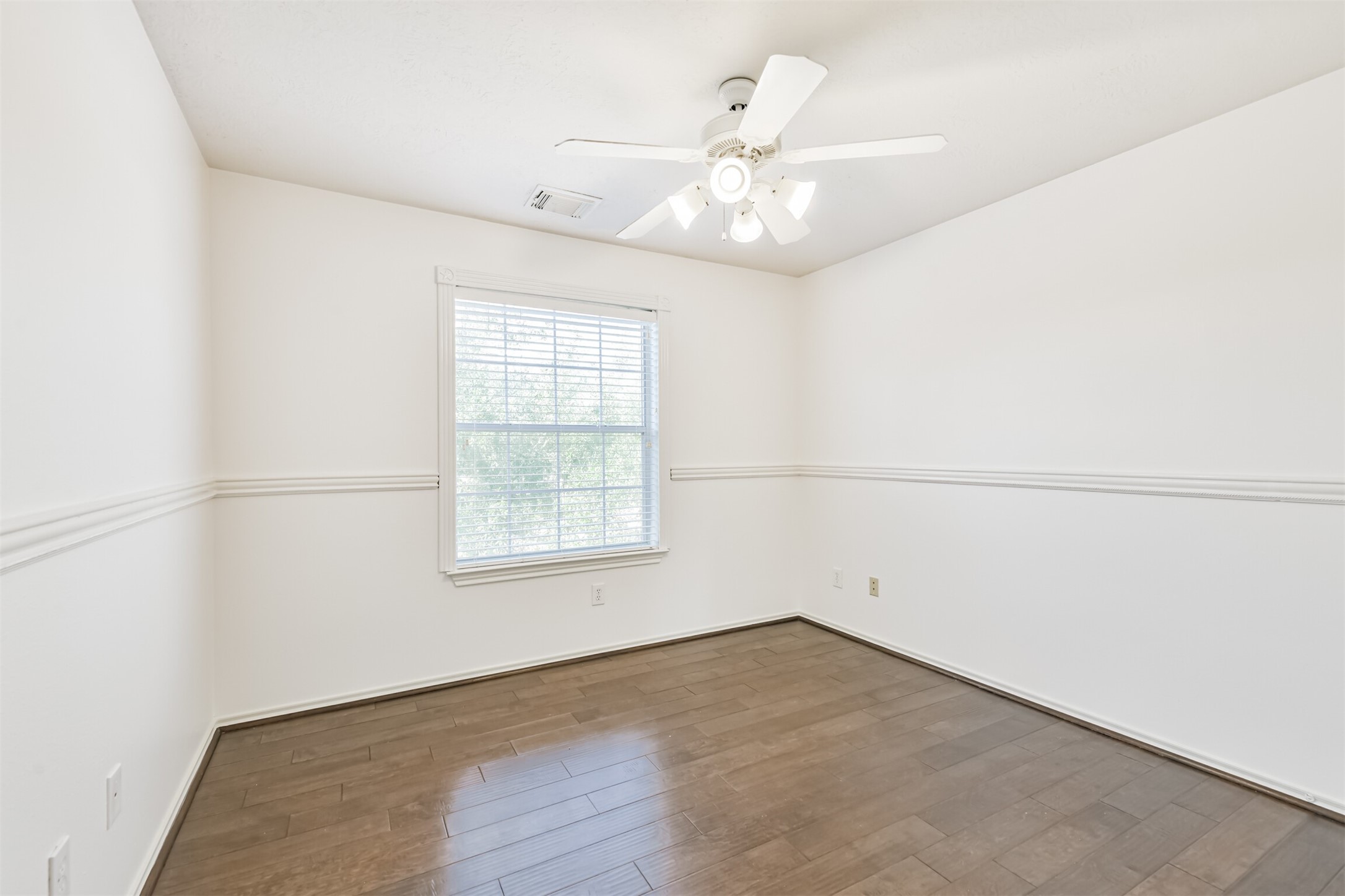 2507 Liza Court Spring, TX 77388 - Photo 25 of 37 an empty room with wooden floor chandelier fan and windows