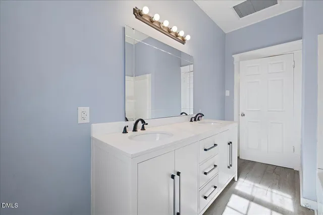 a bathroom with a double vanity sink and mirror