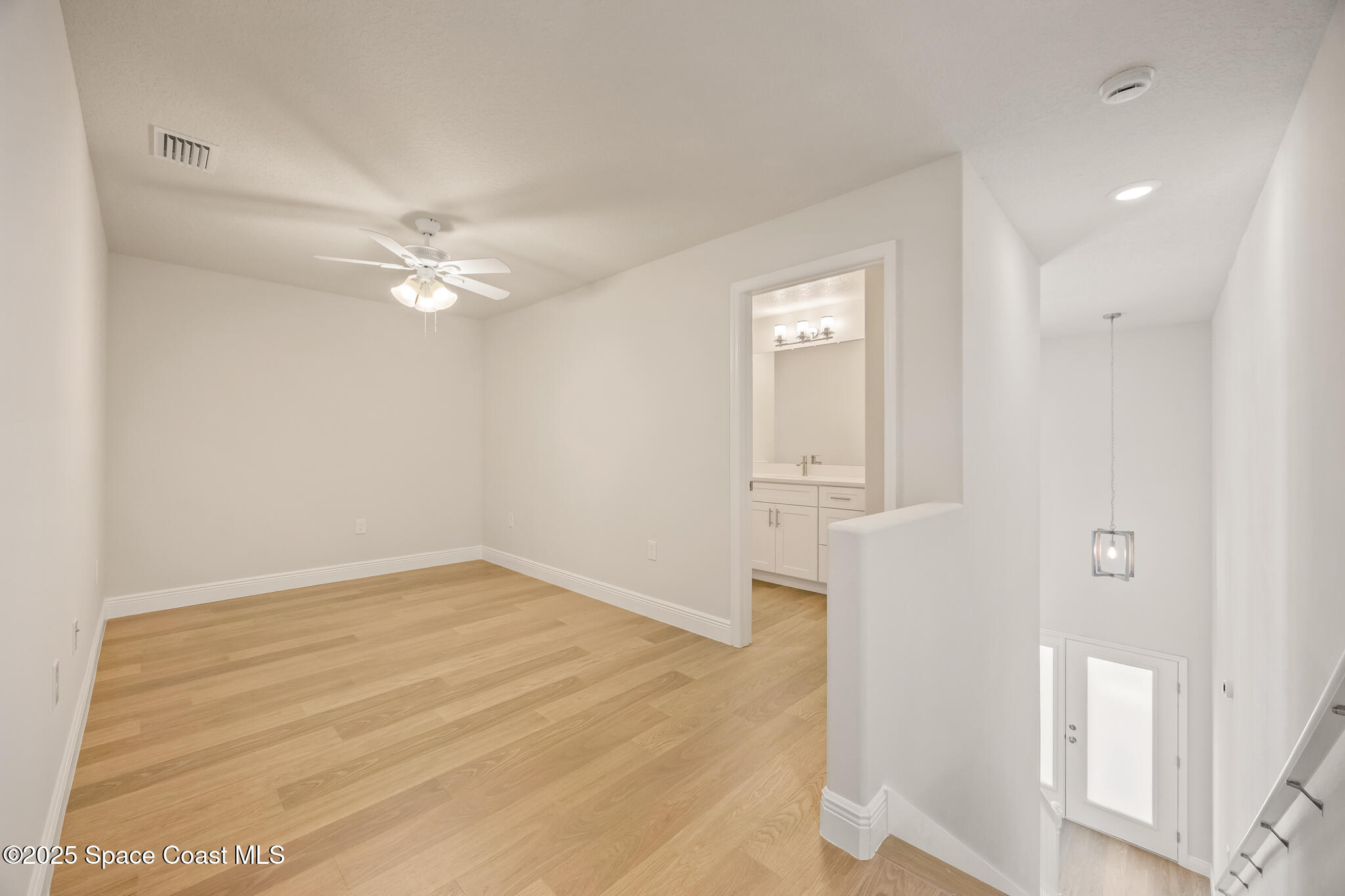 168 Hidden Wds Place Melbourne, FL 32901 - Photo 18 of 31 an empty room with wooden floor and ceiling fan
