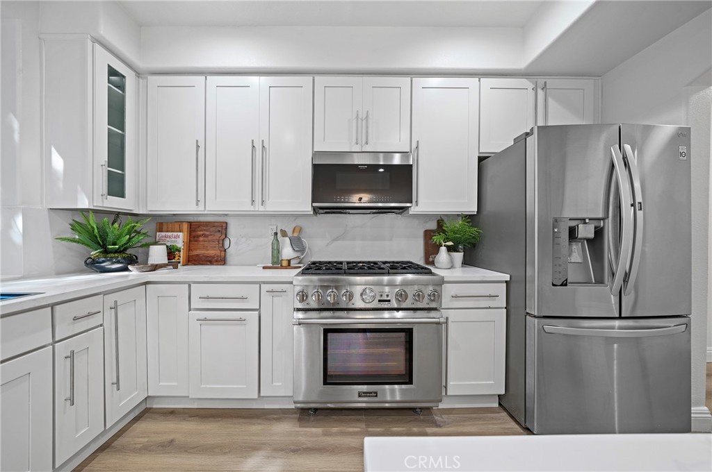 18 Broadleaf Irvine, CA 92612 - Photo 13 of 52 a kitchen with white cabinets and stainless steel appliances