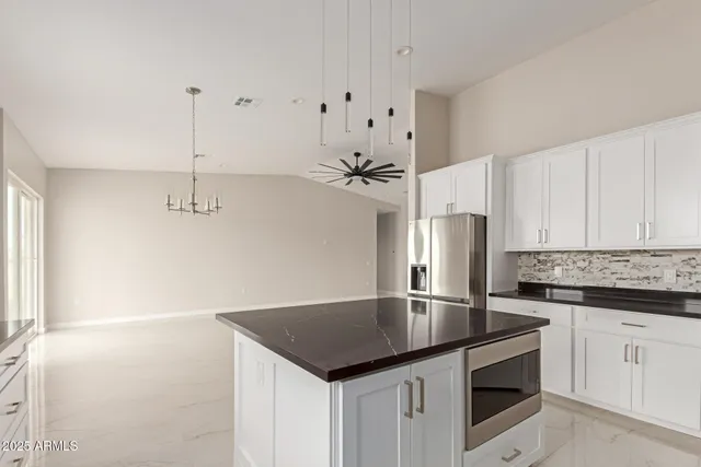 a kitchen with granite countertop a sink cabinets and stainless steel appliances