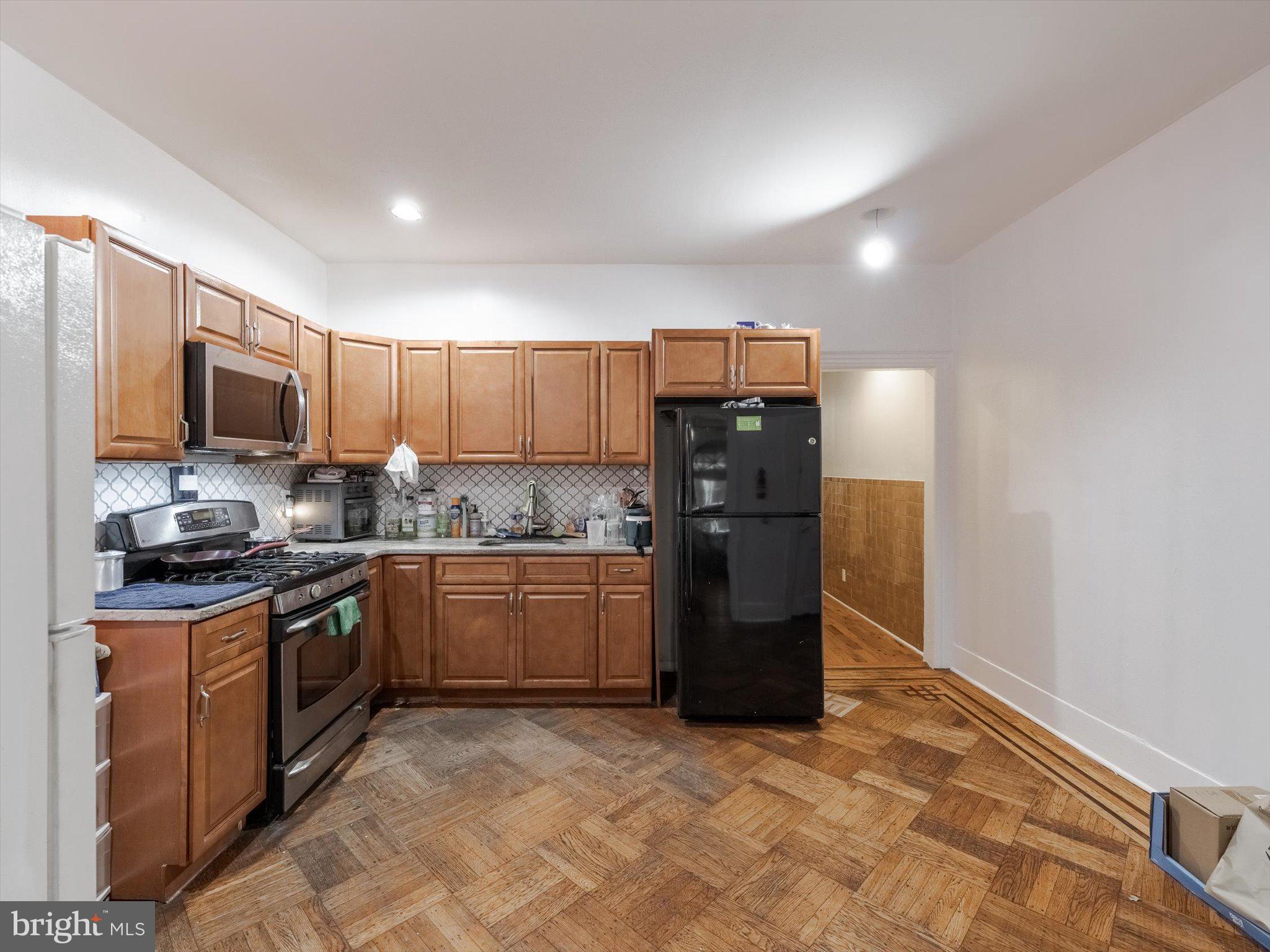 131 South 50th Street Philadelphia, PA 19139 - Photo 10 of 27 a kitchen with granite countertop a refrigerator and a stove top oven