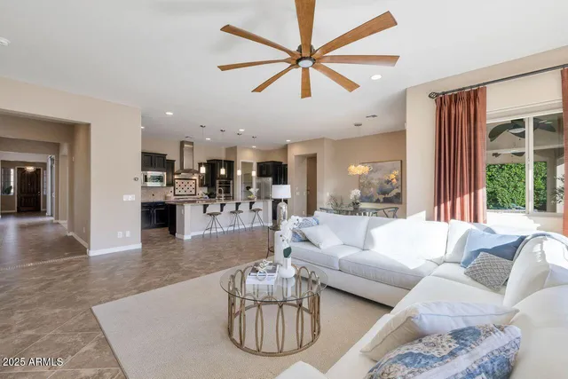 a living room with furniture kitchen view and a large window