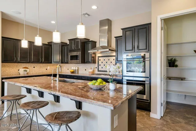 a kitchen with stainless steel appliances granite countertop a sink and a refrigerator