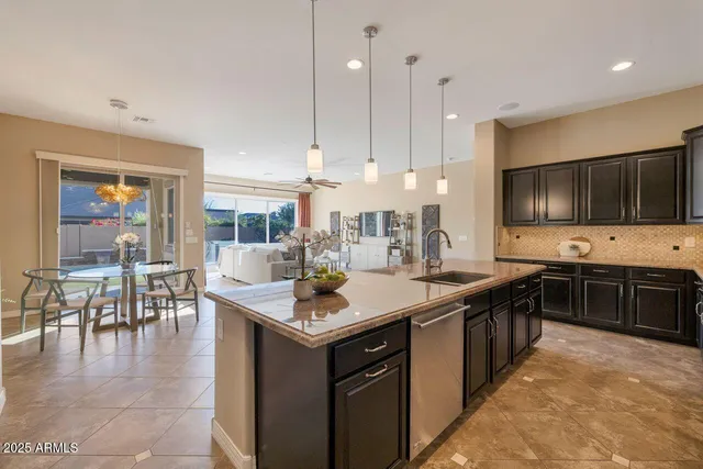 a large kitchen with stainless steel appliances a stove a sink a dining table and chairs
