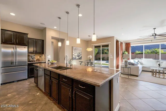 a kitchen with stainless steel appliances granite countertop a sink a stove and a refrigerator