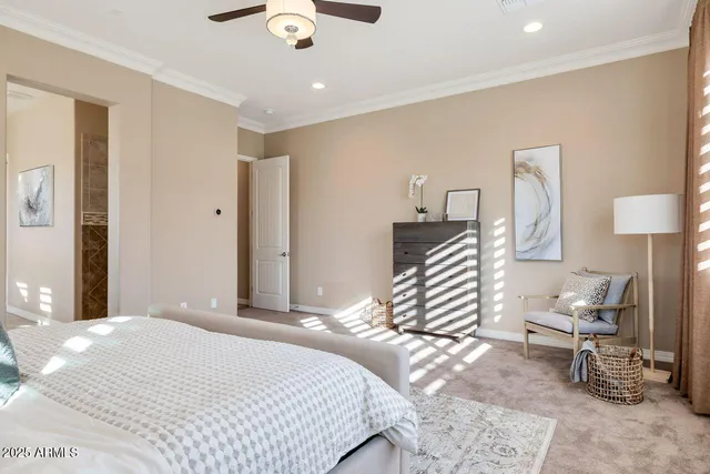 a bedroom with a bed a chair and painting on the wall