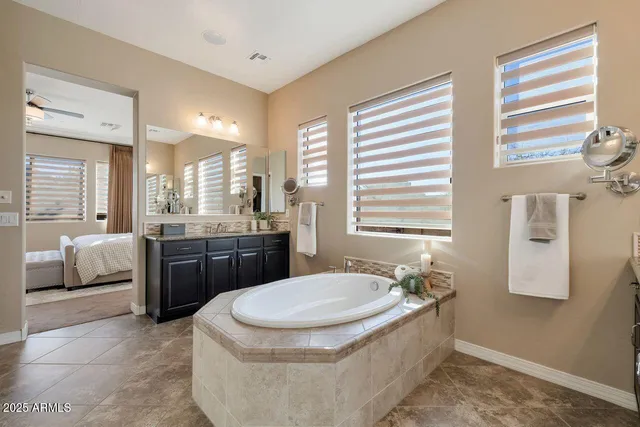 a bathroom with a granite countertop tub sink and mirror