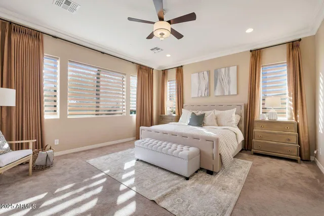 a spacious bedroom with a large bed and a chandelier