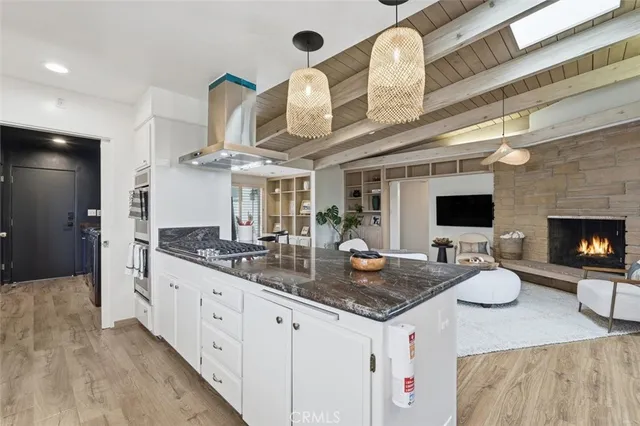 a large kitchen with granite countertop a sink and a fireplace