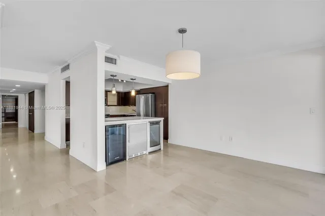 a large white kitchen with stainless steel appliances kitchen island a stove a refrigerator a sink dishwasher a oven with a dining table and chairs