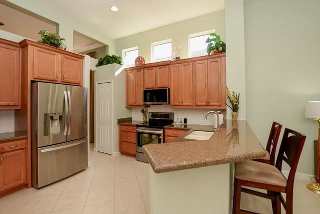 a kitchen with stainless steel appliances granite countertop a refrigerator and a sink