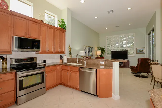 a living room with couch a large window and a chandelier