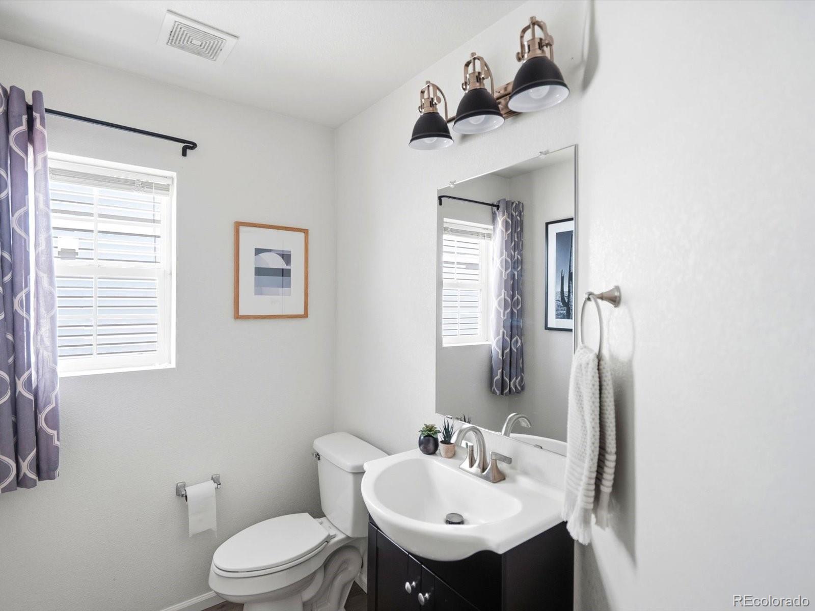 5444 Perth Court Denver, CO 80249 - Photo 19 of 46 a bathroom with a sink mirror and toilet