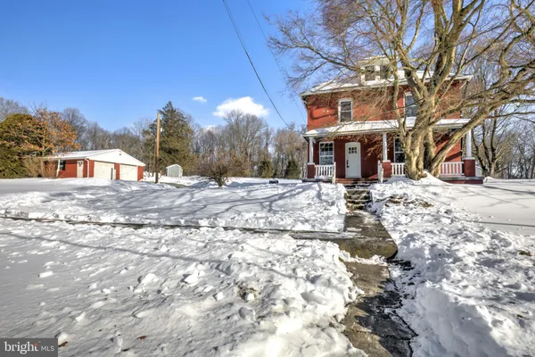 a view of a house with snow on the road
