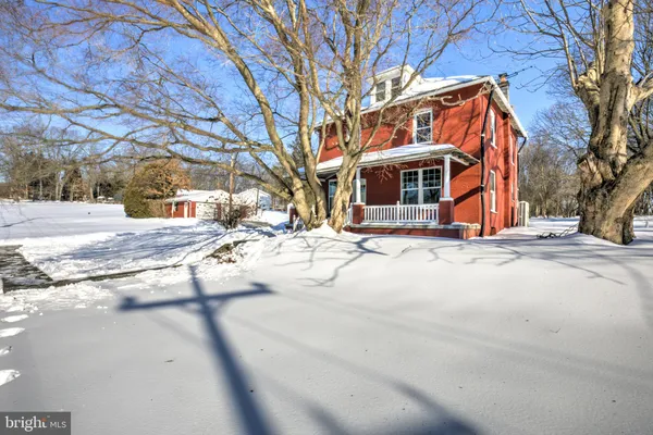 a view of a white house with a yard covered in snow