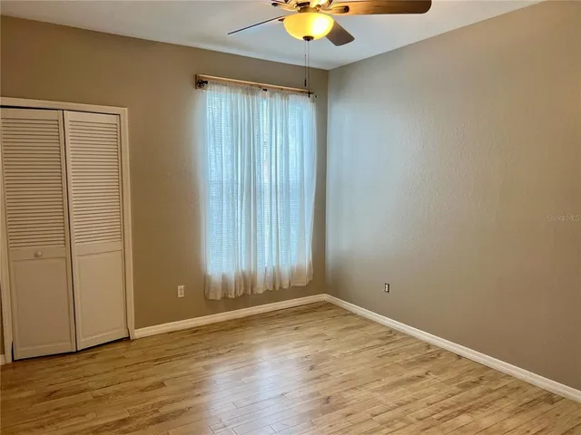 an empty room with wooden floor and window