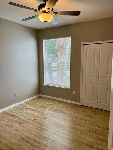 an empty room with windows and fan