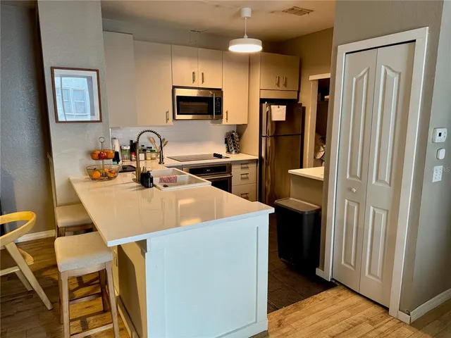 a kitchen with a sink a counter top space and stainless steel appliances