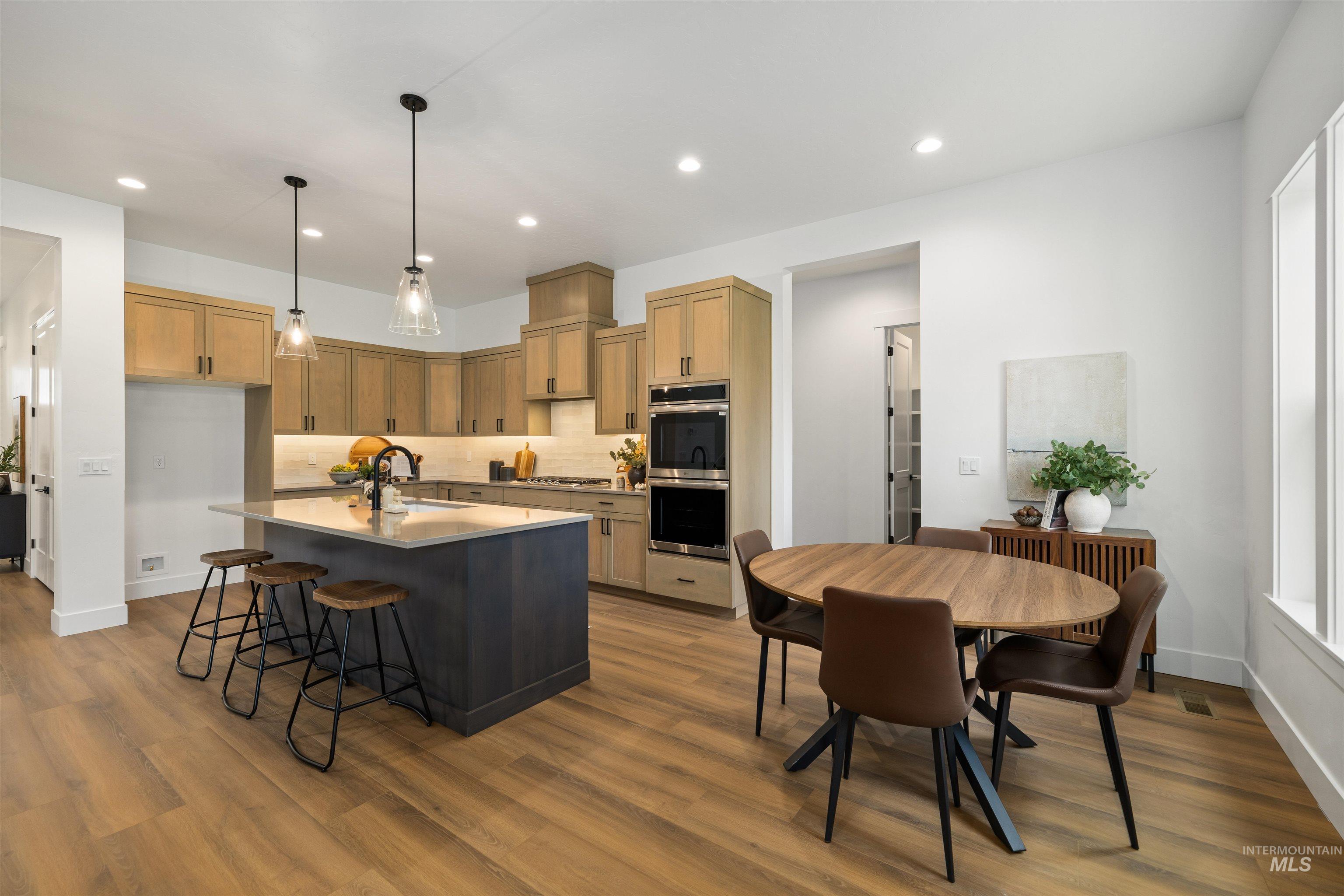 611 North Hiltonhead Way Eagle, ID 83616 - Photo 14 of 38 Kitchen featuring a breakfast bar area, pendant lighting, a center island with sink, appliances with stainless steel finishes, and recessed lighting