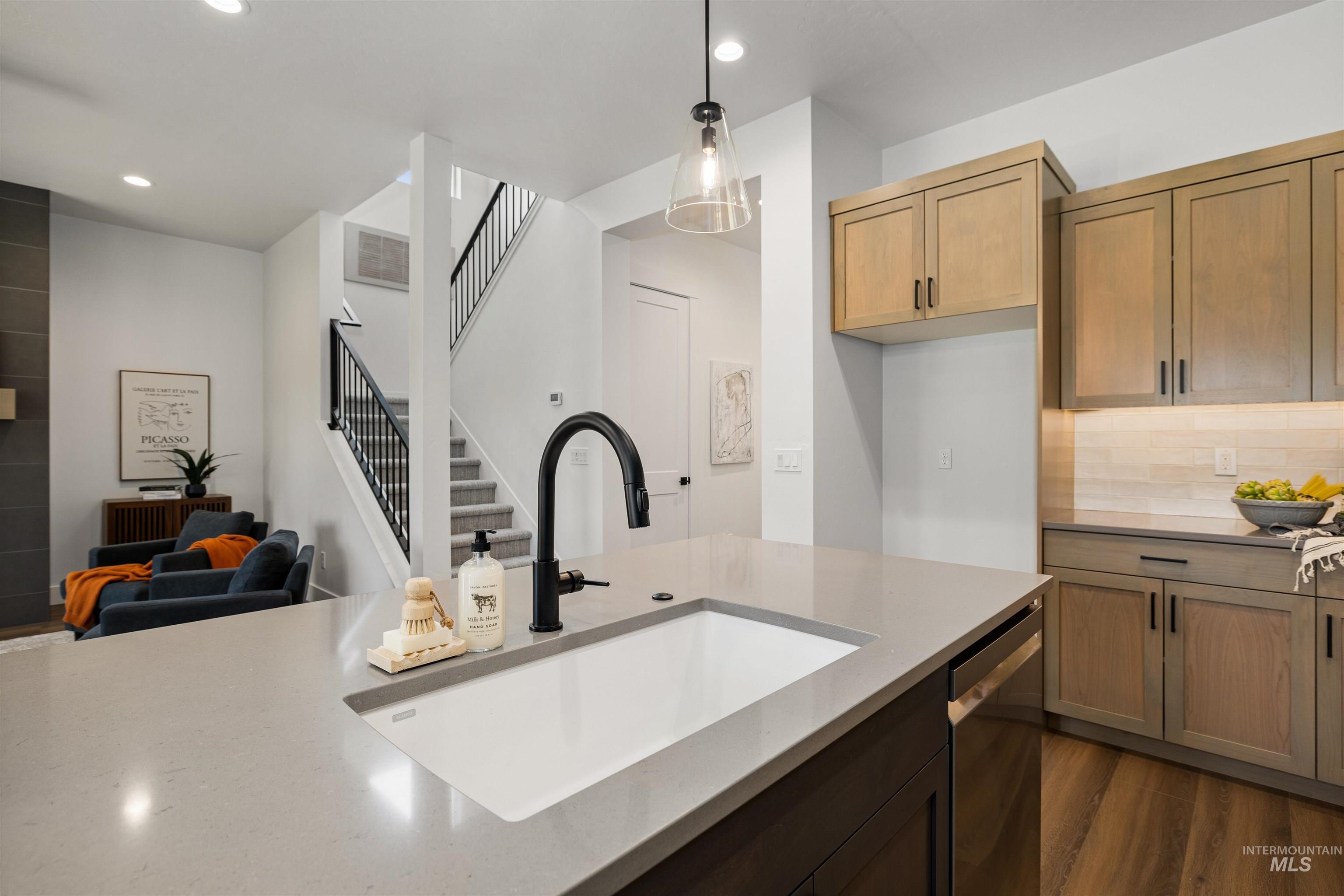 611 North Hiltonhead Way Eagle, ID 83616 - Photo 38 of 38 Kitchen with pendant lighting, dark wood finished floors, stainless steel dishwasher, open floor plan, and dark stone countertops