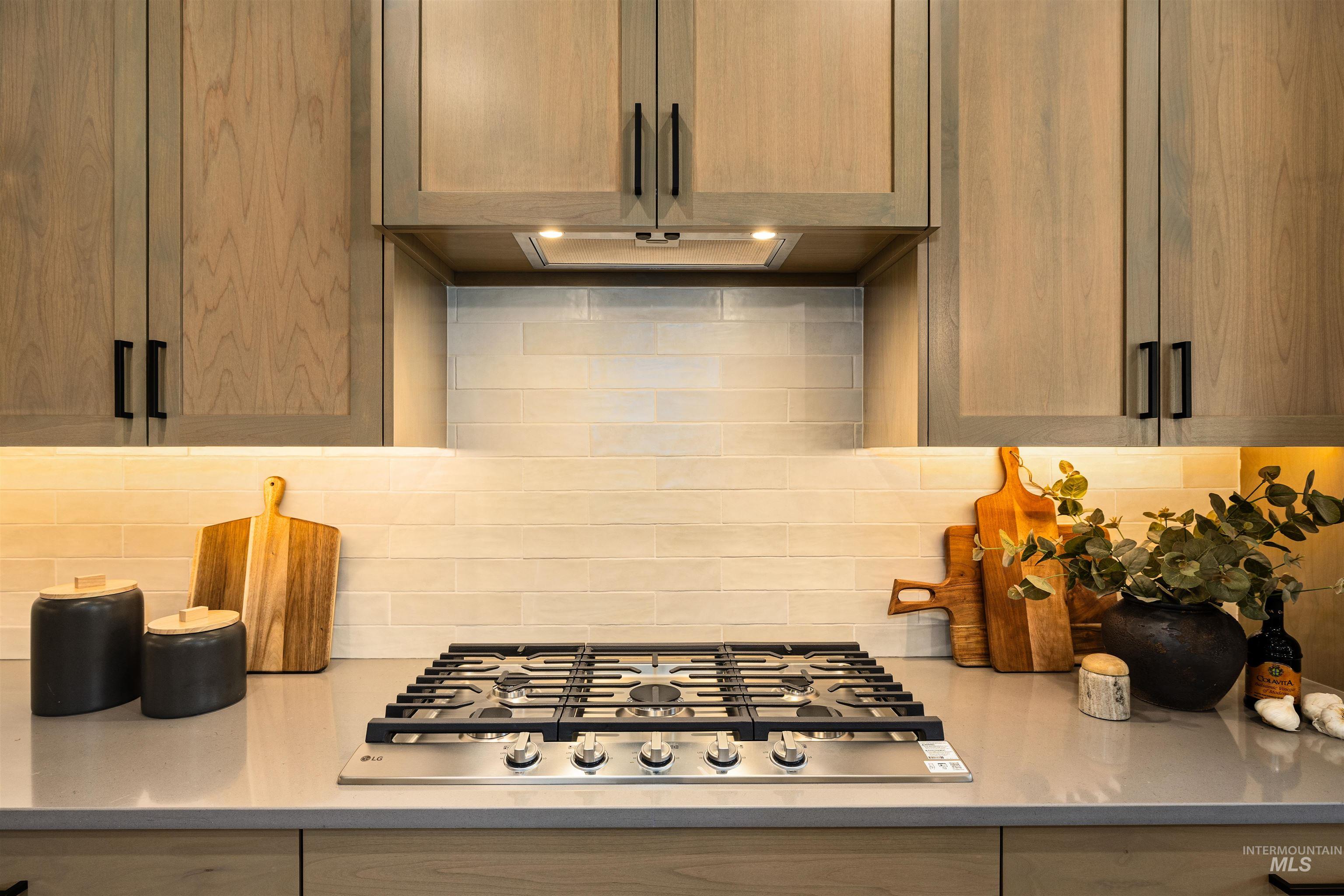 611 North Hiltonhead Way Eagle, ID 83616 - Photo 18 of 38 Kitchen with stainless steel gas stovetop, tasteful backsplash, and light stone countertops