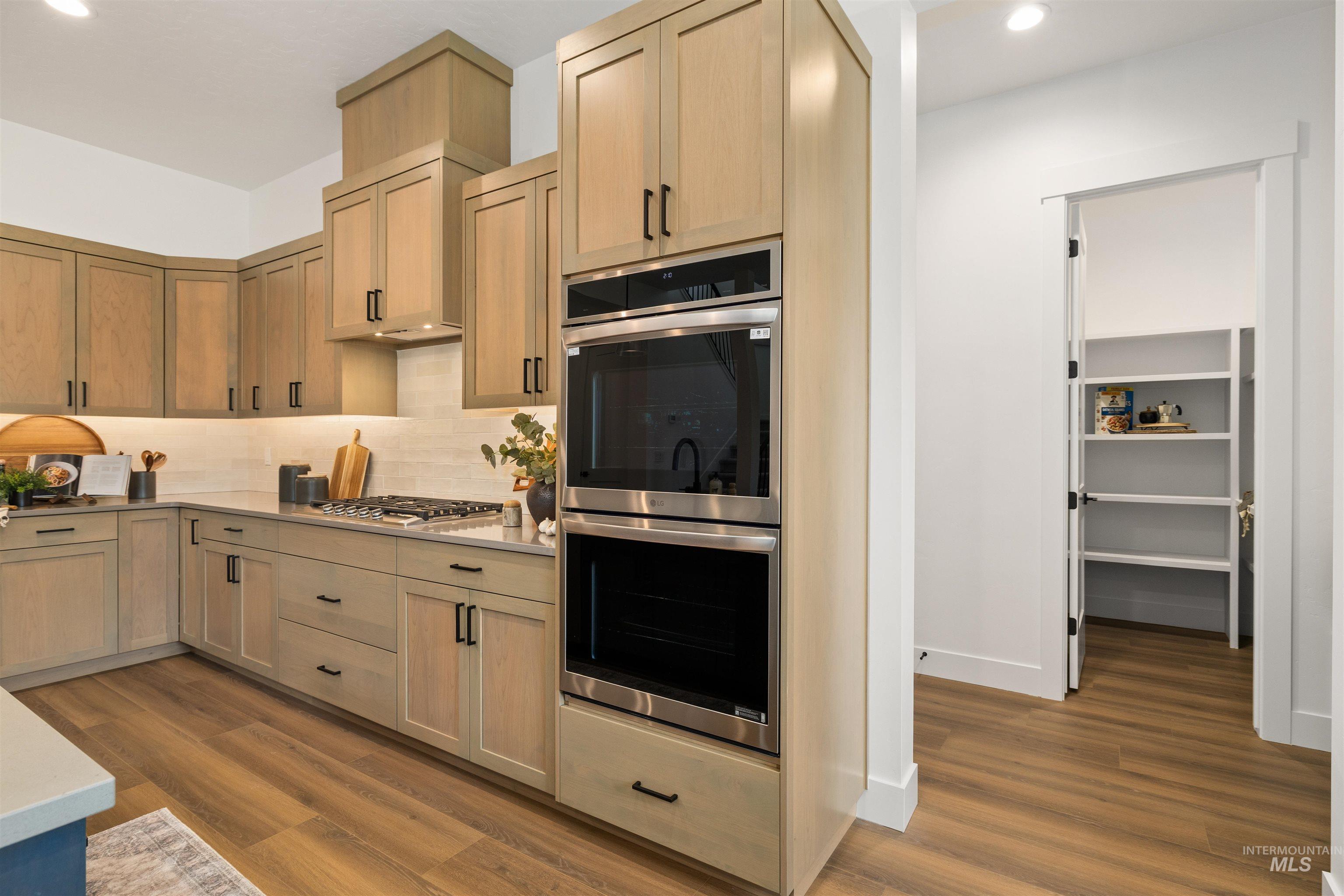 611 North Hiltonhead Way Eagle, ID 83616 - Photo 19 of 37 Kitchen featuring appliances with stainless steel finishes, dark wood-style floors, backsplash, recessed lighting, and light brown cabinets. Photo Similar.