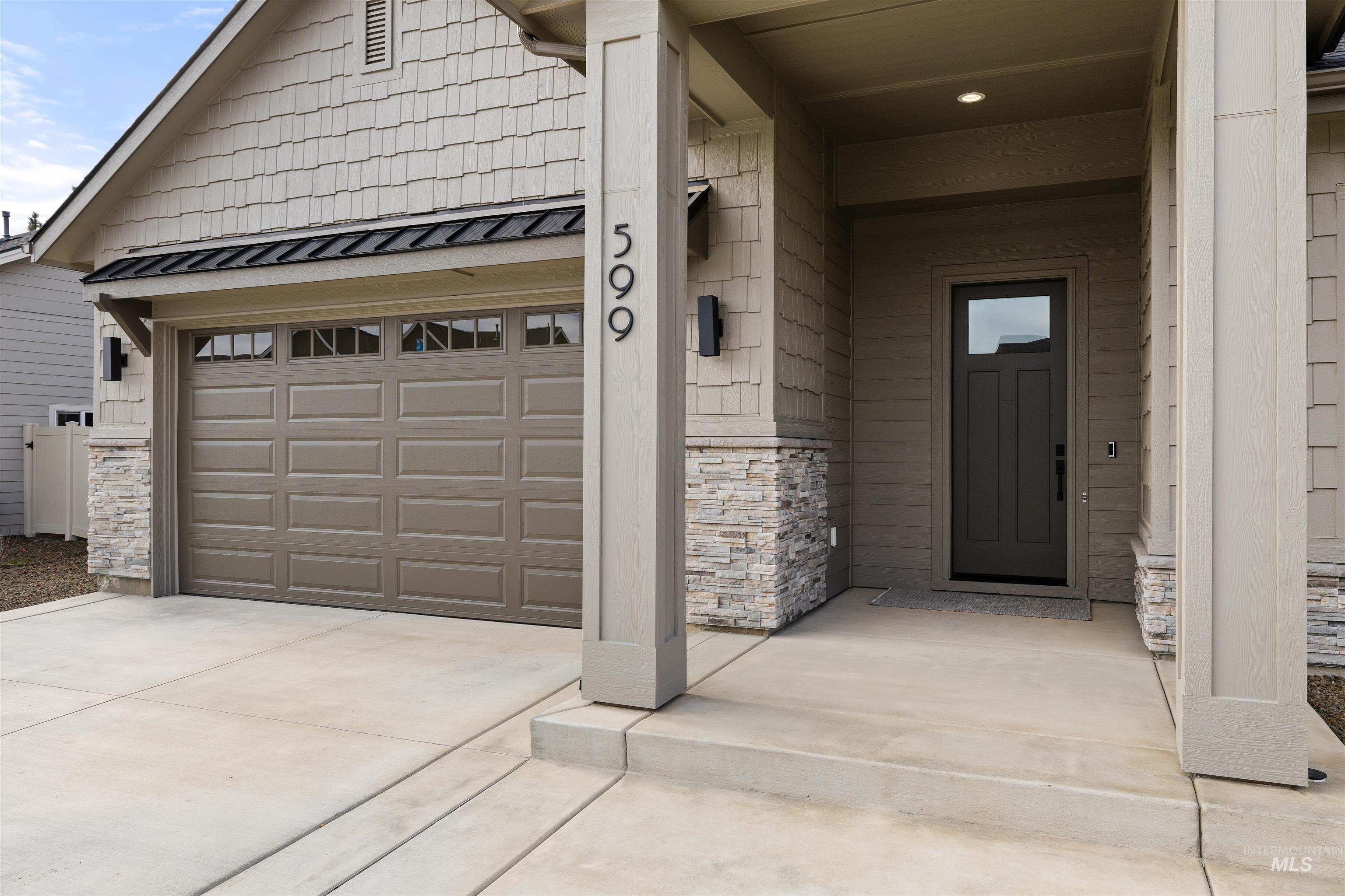 611 North Hiltonhead Way Eagle, ID 83616 - Photo 3 of 38 Property entrance featuring stone siding, a porch, driveway, and a metal roof