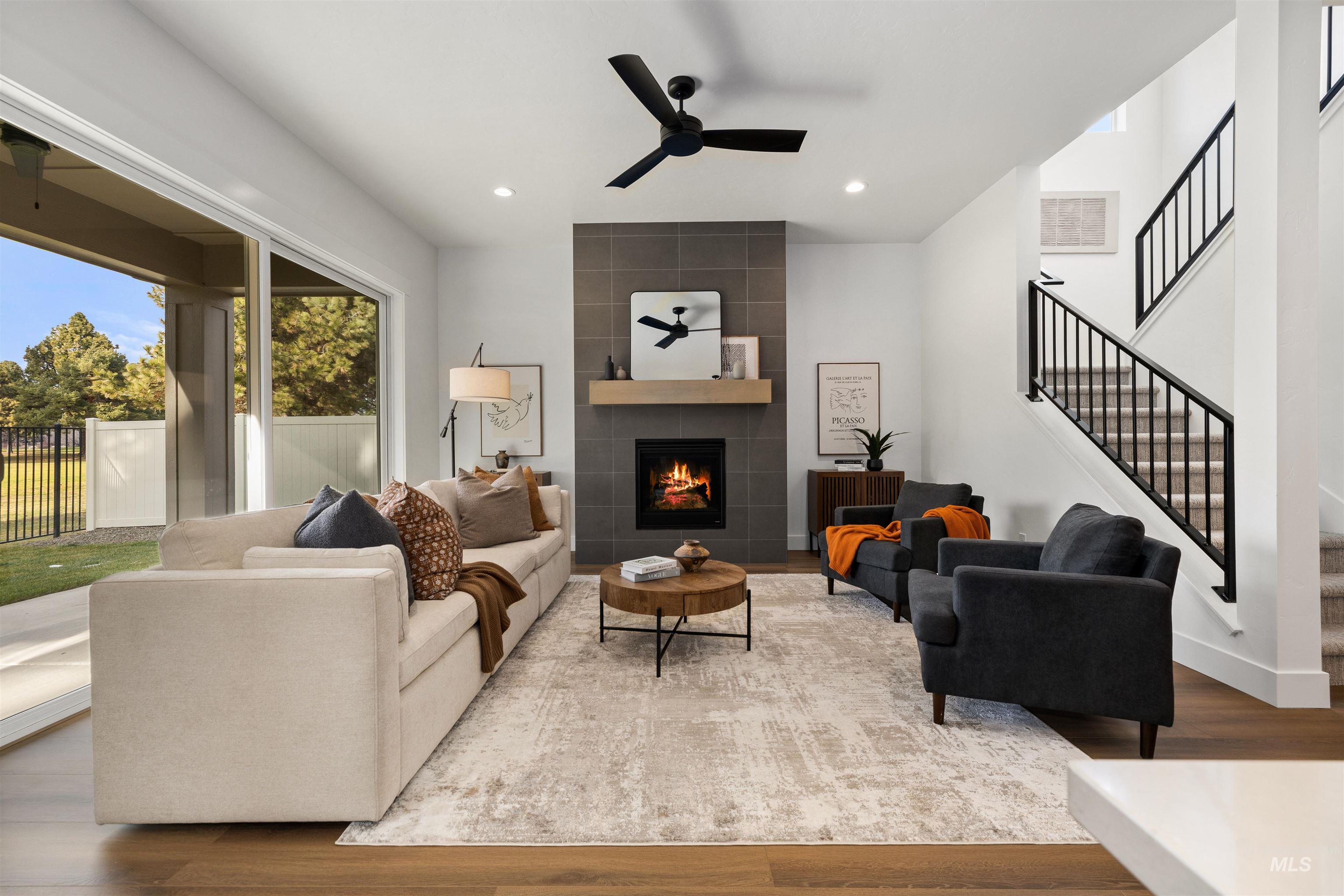 611 North Hiltonhead Way Eagle, ID 83616 - Photo 10 of 38 Living area with a tile fireplace, stairs, ceiling fan, wood finished floors, and recessed lighting